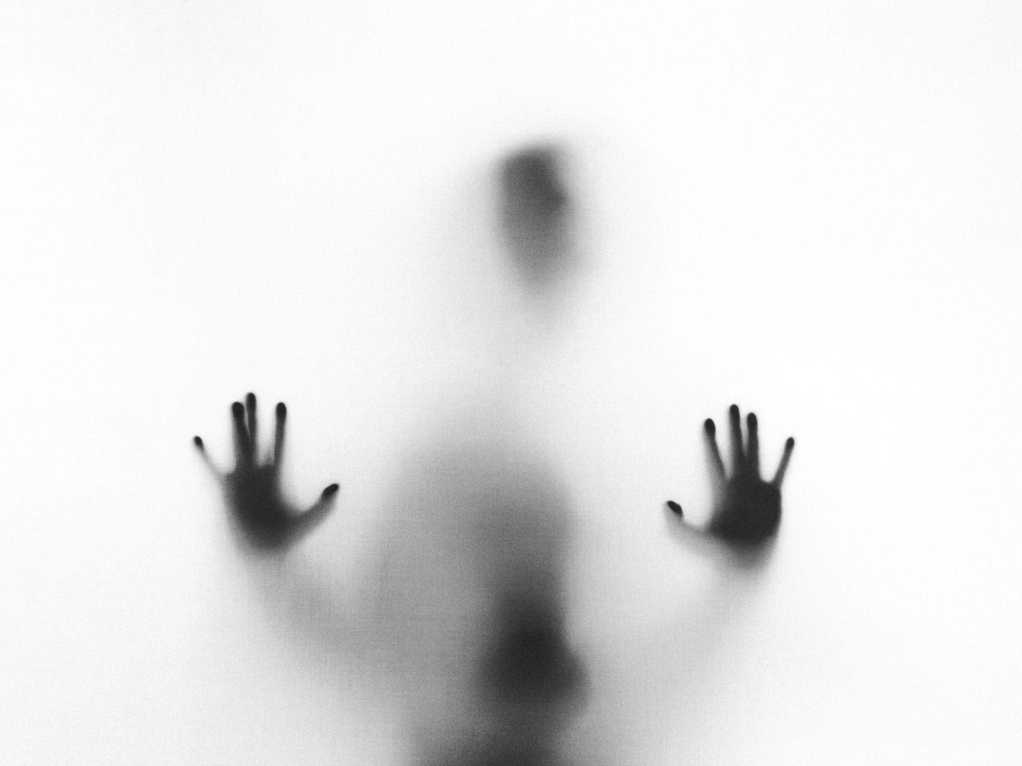silhouette of person behind a smoky glass.