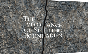 A cracked slab of rock with the words "The Importance of Setting Boundaries" written. The crack in the slab causes the letters to also appear to be broken.